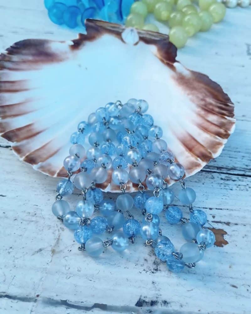 Smuk halskæde med perler i forskellige lyseblå nuancer.