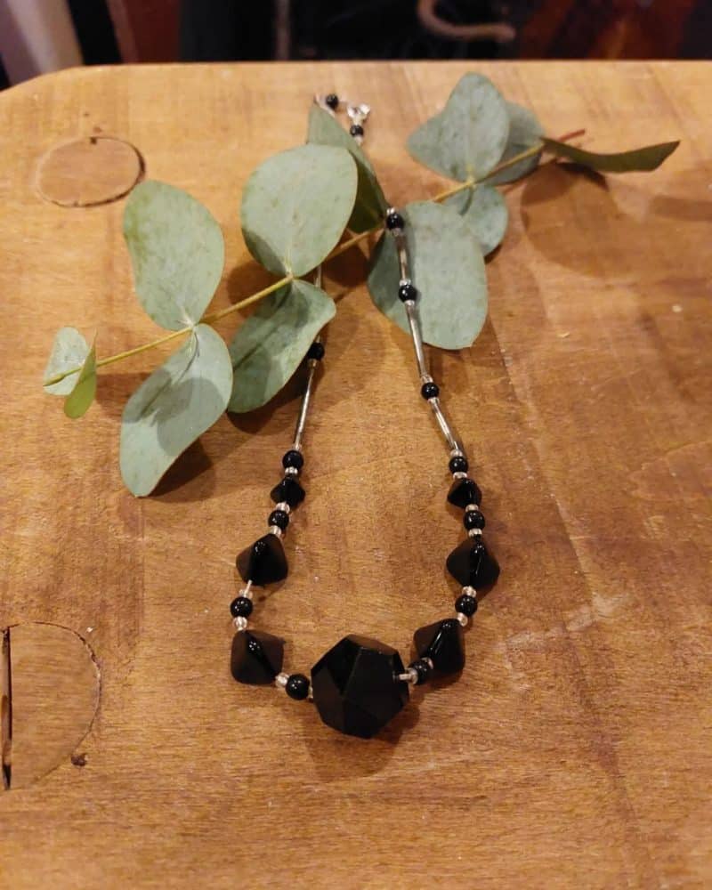 Smuk halskæde med sorte "sten" i forskellige størrelser.