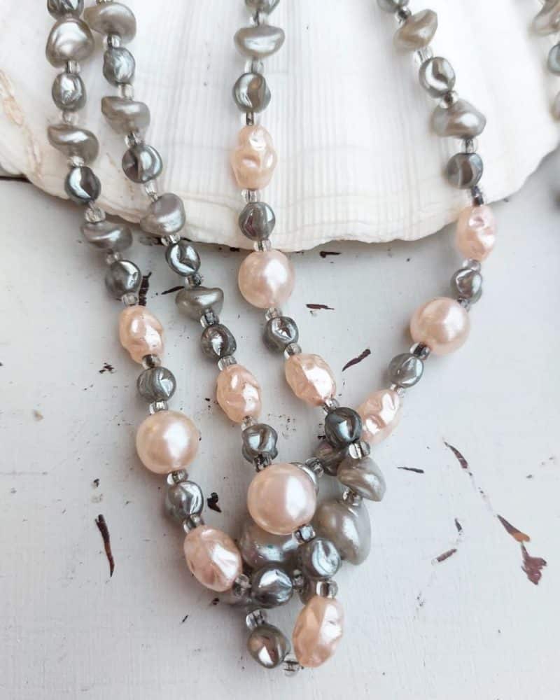Smuk halskæde med perler i og sten i rosa og grå.