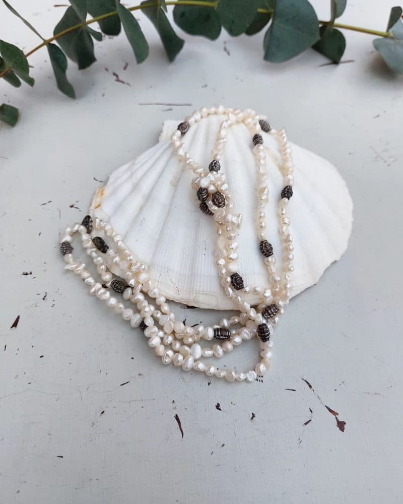 Smuk halskæde med perler og sten I hvid og grå.