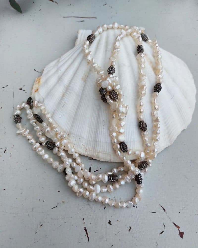 Smuk halskæde med perler og sten I hvid og grå.