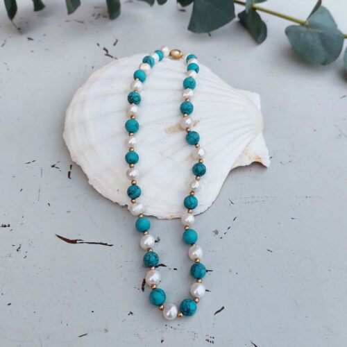 Smuk halskæde med perler og sten i lyseblå nuancer.
