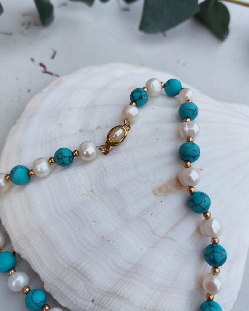 Smuk halskæde med perler og sten i lyseblå nuancer.