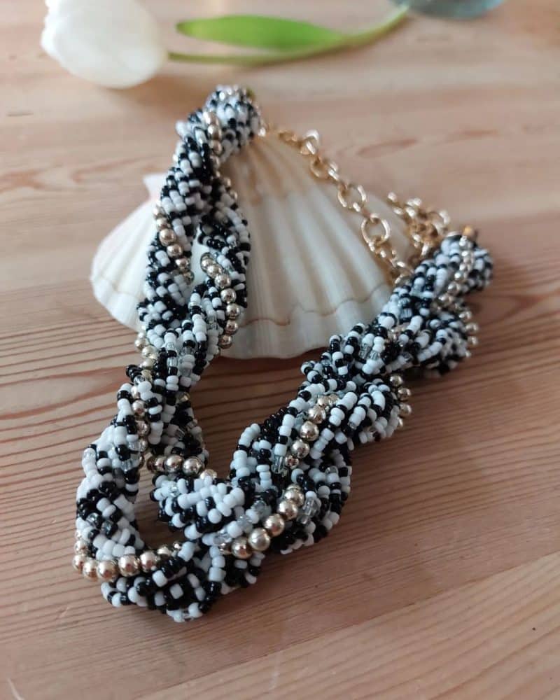 Super smuk bijouteri halskæde med små sorte, hvide og guld perler.