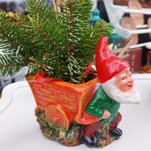 Skøn julemandsurtepotte skjuler, som trækvogn bag julemand med stort skæg og nissehue.