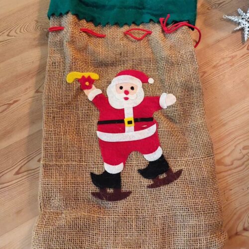 Skøn ældre julesæk med filt julemand på skøjter og rød snor.